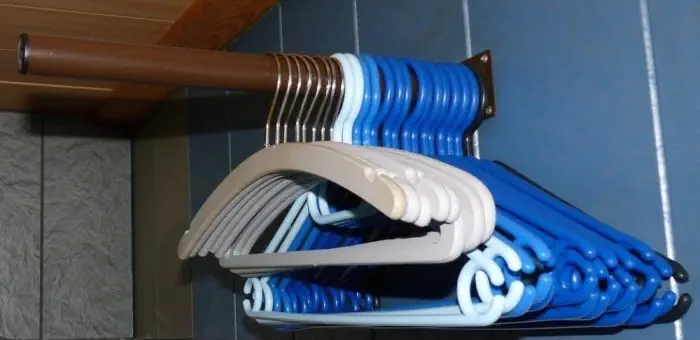 Ungenutzte Kleiderbügel an Tischbein hängen.